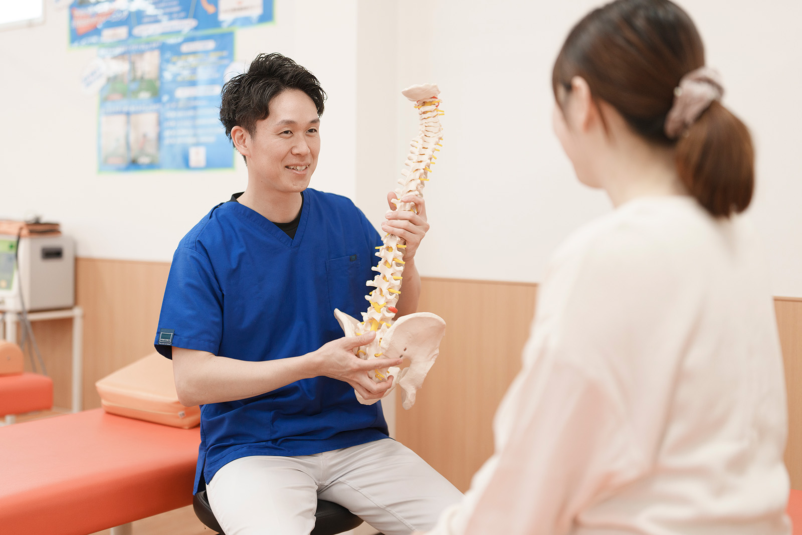 骨格模型を手に患者様に説明している写真