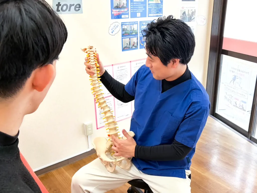 骨模型を持って説明している写真